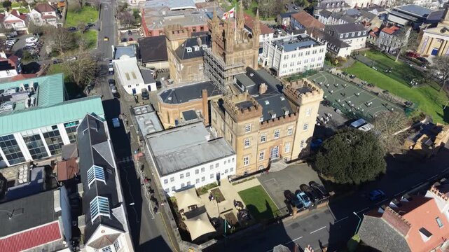 Elizabeth College St Peter Port Guernsey rooftop footage rising to show views across town to Belle Greve Bay and St Sampson in late afternoon sun with blue sky