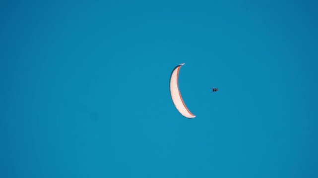 Paragliding in the blue sky during summer day at Manali, Himachal Pradesh, India. Tourist enjoying thrill and freedom of paragliding. Concept of adventure sports and outdoor enthusiasts.