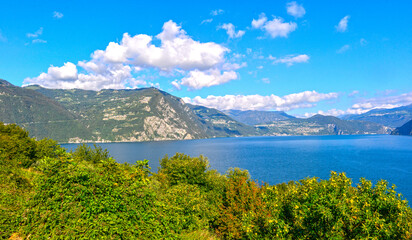 Obraz premium Weites Landschaftspanorama des Iseosees mit blauem Wasser und umliegenden Bergen, Italien