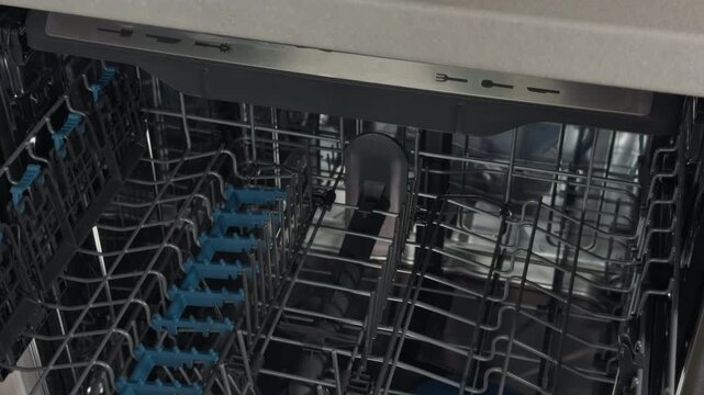 Dishwasher rack visuals. Detailed shot of dishwasher upper shelf with reflective chrome surfaces