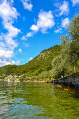 Fototapeta premium Blick über den Iseosee auf die Burg Rocca Martinengo und die umliegenden Berge, Italien