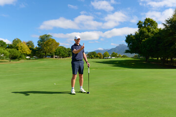 Fototapeta premium Man pointing on golf course with putter