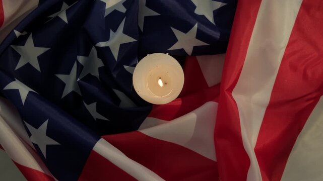 American flag and burning candle, top view, close-up