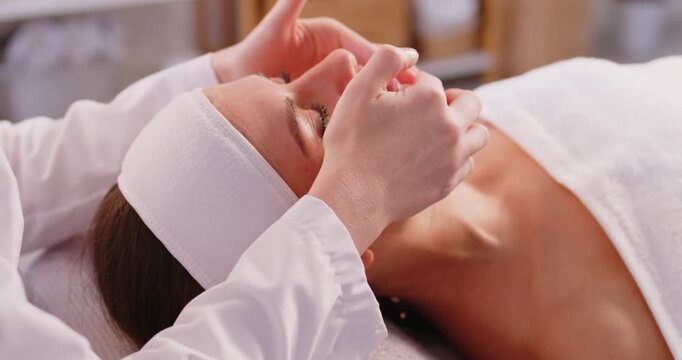 Cosmetologist spa beautician doing face massage of female skin care using beauty treatments, perfect healthy appearance, wellness beauty salon dermatologists professional service for rejuvenation