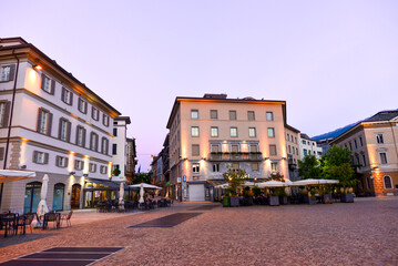 Fototapeta premium Abendliche Piazza Garibaldi in Sondrio mit gemütlichem Straßencafé, Italien