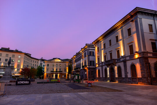 Abendliche Piazza Garibaldi in Sondrio mit beleuchteten historischen Geb&auml;uden, Italien