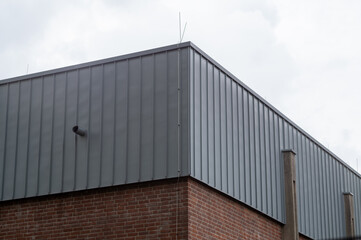 Obraz premium Modern industrial building wall showing corrugated metal and brickwork