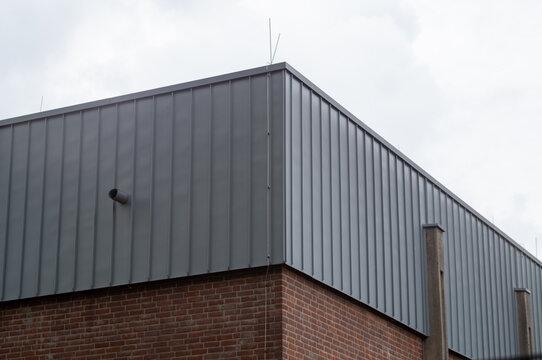 Modern industrial building wall showing corrugated metal and brickwork