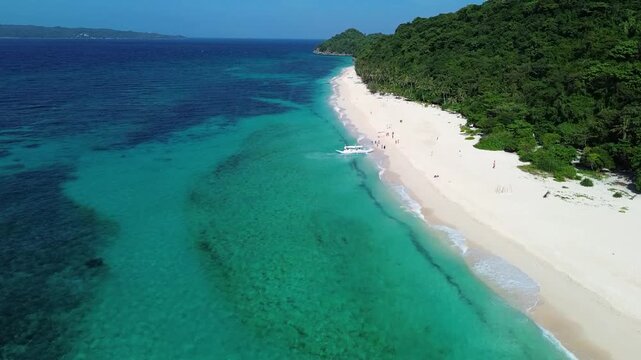 Drone view of tropical Puka Beach on Boracay island with blue ocean, white sandy shore and natural coastline landscape in the Philippines.