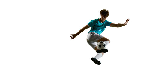 Naklejka premium Soccer player flying with ball under foot in wide copy space composition. Concept of sports banner, football campaign, dynamic training content, product ad layout and explosive energy.