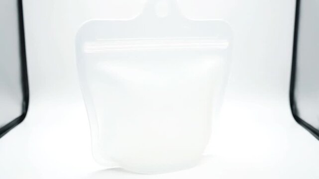 Empty reusable silicone pouch for food storage, eco-friendly, white background.