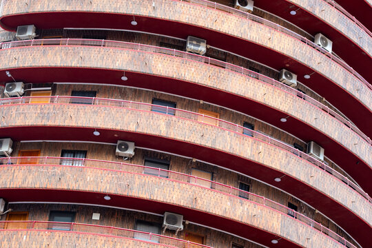 Red arcs highlight balcony geometry and abstract pattern on urban apartment building facade architecture in spain showing modern residential exterior detail