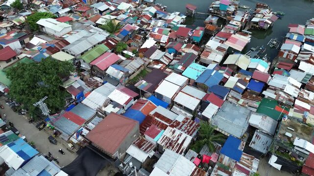 Aerial drone view over crowded urban settlement in Cebu Philippines with tightly packed residential buildings and rooftops.