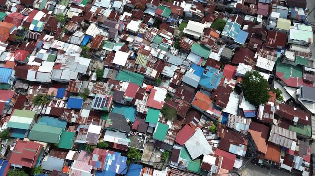 Aerial drone view over crowded urban settlement in Cebu Philippines with tightly packed residential buildings and rooftops.