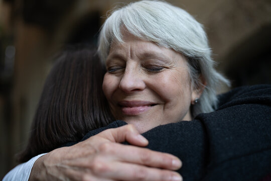 Two female friends embracing each other tightly, showing genuine love and support in their friendship