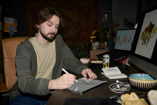 Freelance illustrator working on digital art with graphics tablet