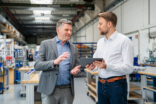 Manager and engineer discussing planning in production hall