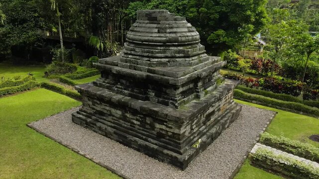 Ancient stone temple in a lush green garden. 4K high-quality heritage footage of Java, Indonesia.