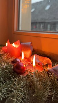 Advent candle by snow window vertical