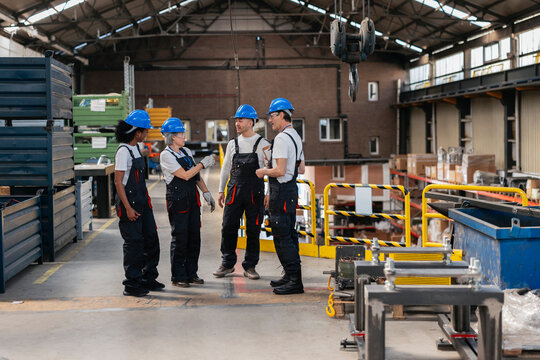 Colleagues talking at industrial manufacturing factory