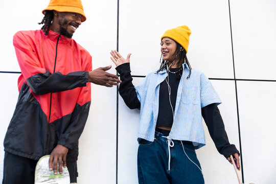 Smiling skateboarders giving a high five in Barcelona