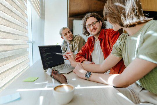 Business team coding software on laptop during office meeting