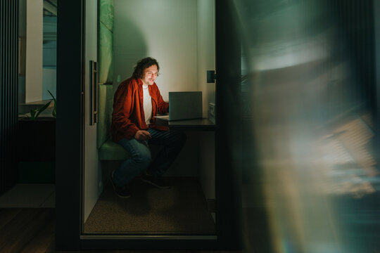 Businessman working on laptop in modern office cubicle