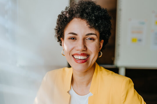 Smiling businesswoman in yellow blazer at the modern office