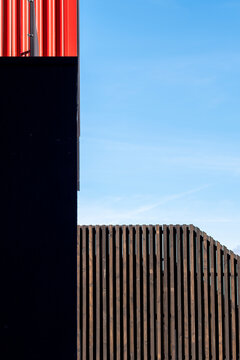 Corrugated fence texture adds geometric contrast to a modern minimalist wall with bold architecture lines under open sky for clean exterior design