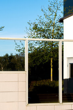 Sky reflection in glass window on a modern minimalist building facade highlights geometric architecture with clean lines and bright exterior mood