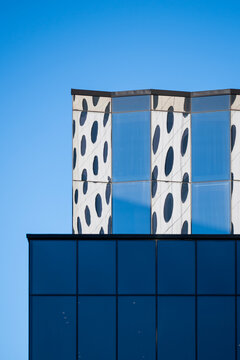 Patterned glass facade of a modern minimalist building with geometric architecture and strong contrast against open sky for clean exterior design