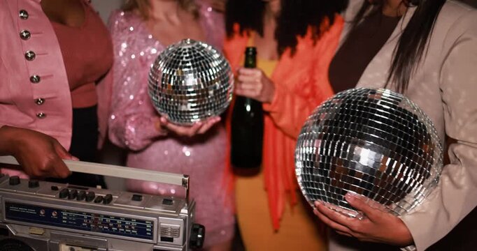Group of multiracial young women with vintage boombox stereo and champagne having fun dancing together outdoor - Party, nightlife, girls and people lifestyle concept - Focus on hand with disco ball