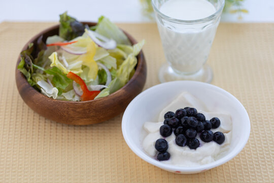 サラダとブルーベリーを乗せたヨーグルトと牛乳の健康的な朝食