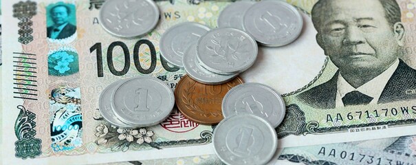 Japanese yen money bills and coins on table. Japan cash of JPY currency close up © Larysa