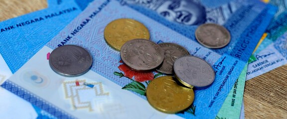 Malaysian ringgit money bills and coins on table. Malaysia cash of MYR currency close up © Larysa