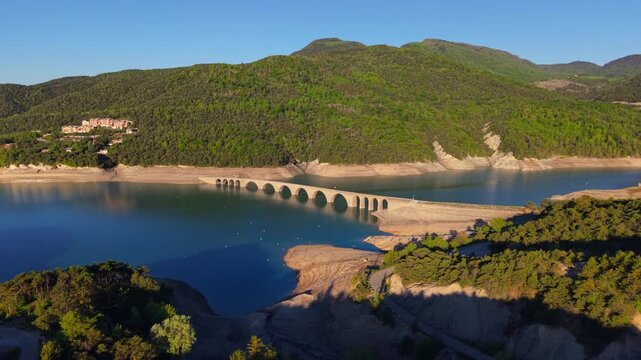 Aerial summer view of Serre-Poncon Lake with Chanteloube Bay and old railroad viaduct in Durance Valley. French Alps, Hautes-Alpes, France