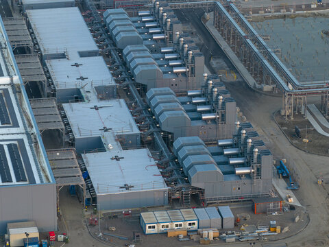 Aerial view of a hyperscale data center facility with rows of cooling units and industrial infrastructure.