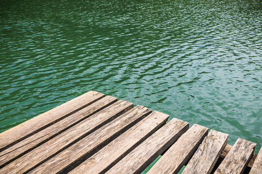 Wooden pontoon pier on a natural lake with copy space