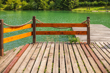 Wooden pontoon pier on a natural lake with copy space © Brebca