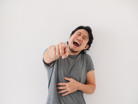Reaction of Asian man laughing of what in front of him, isolated on white.