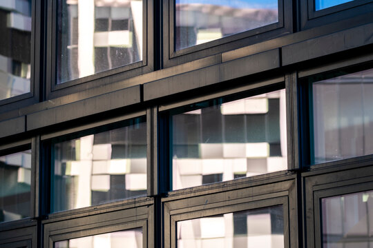 Minimal modern architecture facade building glass reflection windows with abstract pattern geometry featuring crisp grid frames clean rectangles and mirror glare