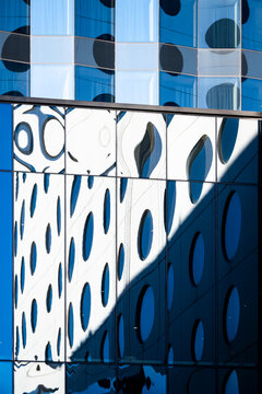 Closeup modern architecture facade building glass reflection windows showing abstract pattern geometry with dotted panels shadows and bold graphic contrast