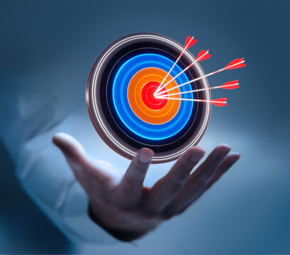 Businessman hand holding virtual target board and arrows hitting center for business target and goal concept on dark blue background