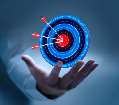 Businessman hand holding virtual target board and arrows hitting center for business target and goal concept on dark blue background