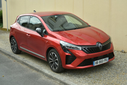 St-Amand Montrond - France - 4 May 2026 - profile view of red renault clio parked in the street