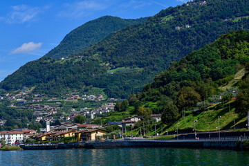 Obraz premium Blick über den Iseosee auf die Uferpromenade und die grünen Berghänge von Marone, Italien