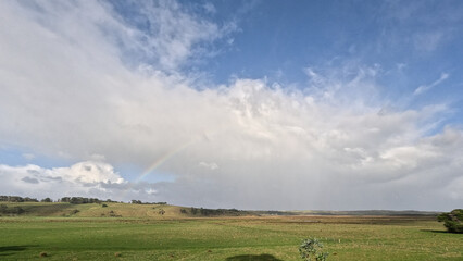 Naklejka premium Scenic View of Green Hills and Rainbow Along Great Ocean Road