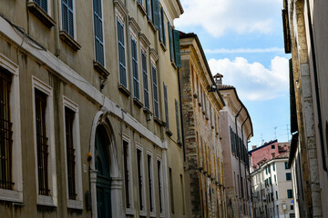 Fototapeta premium Malerische pastellfarbene Häuserfront in der Via Carlo Cattaneo mit Blick zum Dom in Brescia, Italien