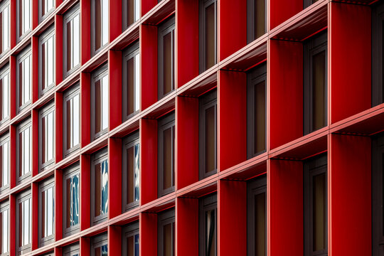 Red facade windows in a grid show geometry and pattern defining modern architecture as an abstract background for bold design layouts