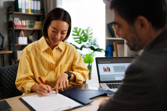 Asian businesswoman signing contract in office meeting
